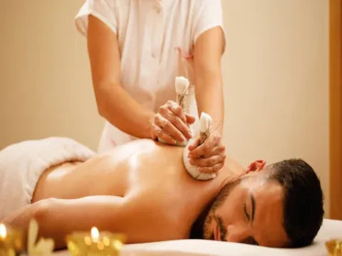 Person receiving a massage with a candlelit setting